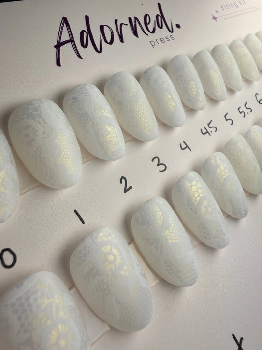 Short Round Press Ons with a warm glow accented with lace. Perfect for a bridal look. 