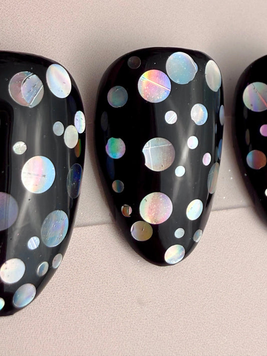 Close up of black nails with holographic dots
