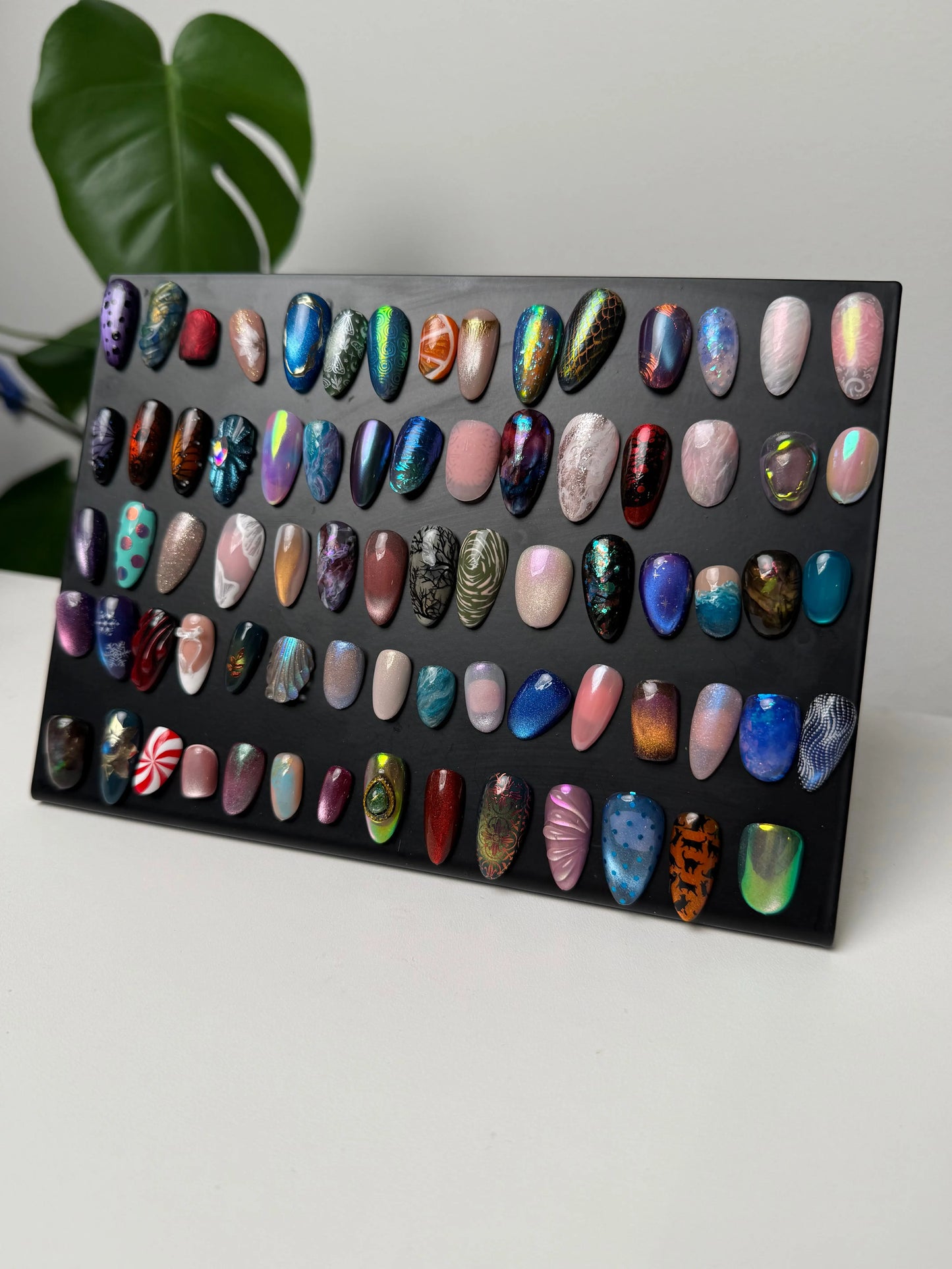Nail art display with various nail shapes and colors on a black background
